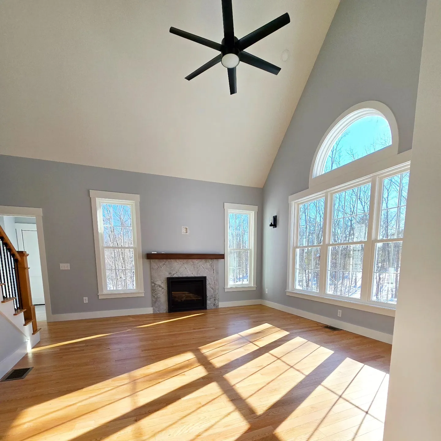 Interior of a freshly painted living room with vaulted ceiling and natural light