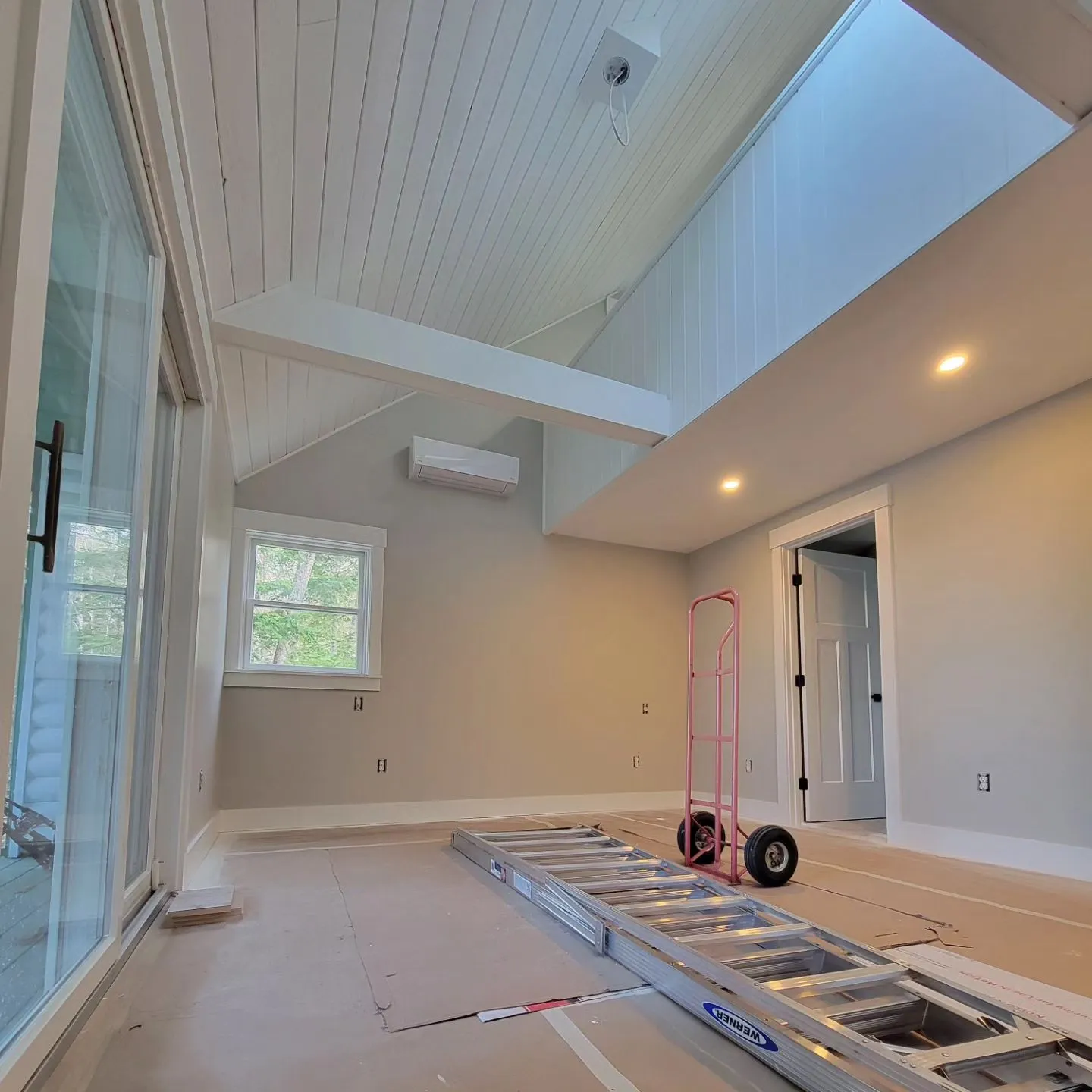 Bright vaulted room mid-job, walls and shiplap ceiling freshly painted in a Raymond, Maine home